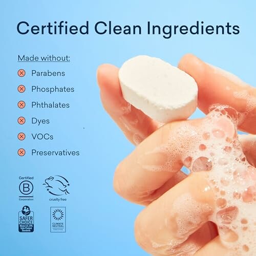 Hand holding a soap with text listing ingredients not included: parabens, phosphates, phthalates, dyes, VOCs, preservatives.