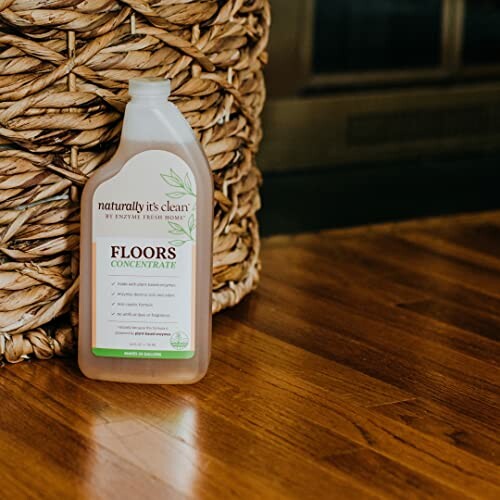 Bottle of floor cleaner on wooden floor next to woven basket.